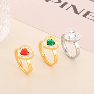 Detailed view of heart rings with red, green, and white crystals in gold and silver finish