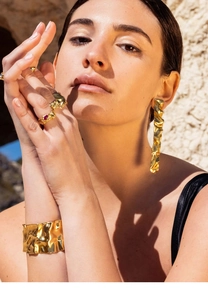 Detailed close-up of 18K gold-plated irregular textured earrings and jewelry set