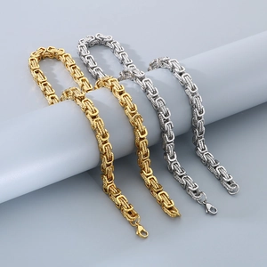 Detailed macro view of gold and silver Byzantine chain bracelets in stainless steel