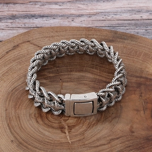 Gros plan d'un bracelet chaîne en argent vintage sur une surface en bois texturée