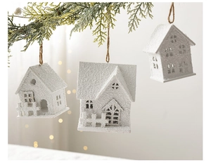 Gros plan d'ornements de maison de neige en bois blanc sur des branches de sapin