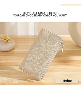 Beige pebble grain leather long wallet with gold zipper on a wooden table setup
