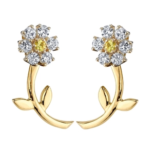 Macro view of gold flower stud earrings with sparkling white zircons and yellow center stones