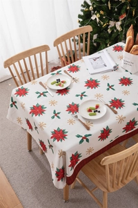 Detail of Christmas tablecloth featuring poinsettia prints and red plaid ribbon edges
