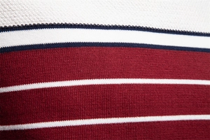 Detailed close-up of premium striped knit fabric with wine red and navy blue textures