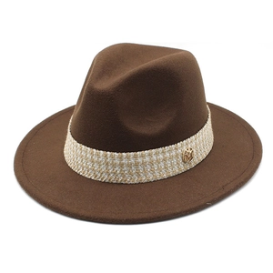 Close-up of brown fedora hat featuring a plaid ribbon band and gold M metal buckle