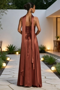 Detail of elegant backless satin evening gown with lace-up straps and silky metallic finish