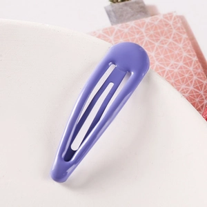 Detail view of a 5cm purple teardrop-shaped candy color hair clip on white round surface