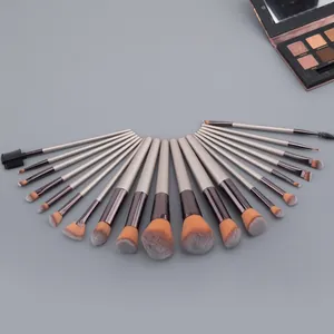 Champagne gold 20-piece makeup brush set with gradient bristles on a grey background