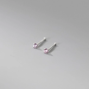 Detailed view of sterling silver four-prong stud earrings with pink cubic zirconia stones