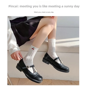 Close-up of white mesh mid-calf socks with cherry embroidery and black pearl Mary Janes