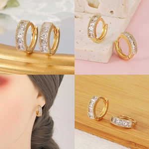 Detalle de aros en oro de 18K con circonitas blancas cuadradas y vista de modelo puesta
