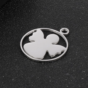 Macro view of silver stainless steel angel silhouette pendant on black texture background