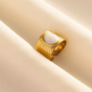 Macro di anello dorato quadrato con trama a raggiera e intarsio ovale in bianco