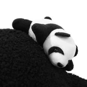 Close-up of a cute plush panda ornament on a black fleece warm baseball cap fabric