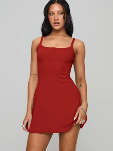 Détail de mini-robe rouge côtelée montrant les trois boutons et la texture du tissu