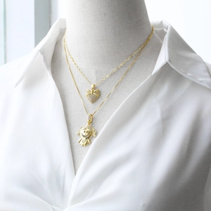 Gold plated heart and cartoon girl pendant necklace set styled on white shirt for women