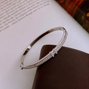 Silver bangle with pavé rectangular zircons and H-letter buckle on leather texture