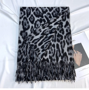 Detailed view of gray leopard print scarf with fine twisted tassels and soft texture