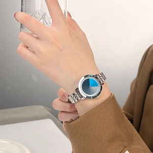 Minimalist silver steel mesh watch with dual-tone blue gray dial on model's wrist