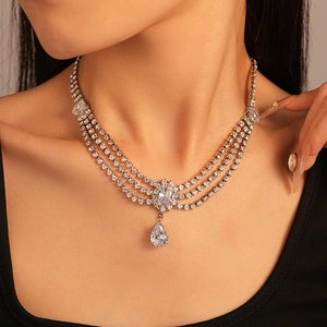 Détail d'un collier multicouche en argent avec zircon poire et pendentif en cristal