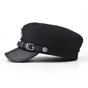 Détail d'une casquette militaire noire avec bouton ancre en métal et visière en cuir