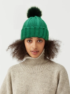 Close-up of bright green ribbed knit beanie with a dark green faux fur pom-pom detail