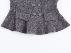 Detail of grey double-breasted knit cardigan with flap pockets and peplum hem