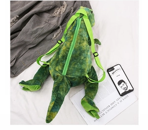 Detail of plush dinosaur backpack showing vibrant green adjustable straps and zipper closure