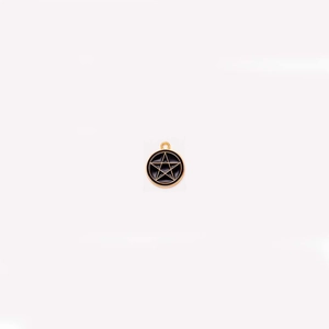 Detail of a golden round pendant featuring a black enamel pentagram star and top loop