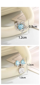 Detailed view of silver bow earrings with light blue heart zircon and dimensions