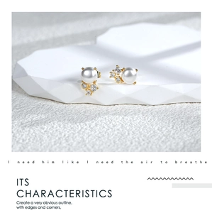 Macro detail of gold plated pearl earrings with zircon inlay and sharp geometric contours