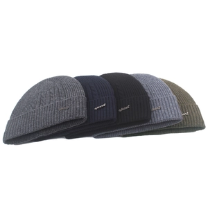 Detail of five assorted colors knit wool beanies with sport metal logo for winter