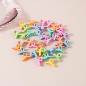 Detailed top view of various pastel mini flower hair claws on a clean cream background
