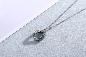 Detailed view of silver titanium steel necklace featuring an irregular diamond pavé pendant