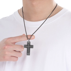Detail of vintage silver cross pendant on a double-layer chain worn by a male model