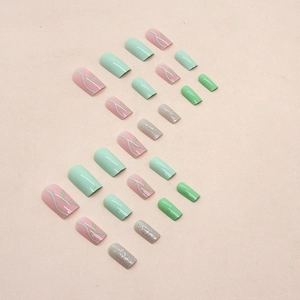 Green and pink press-on nails with glitter ripples and wavy lines in trapezoid shape