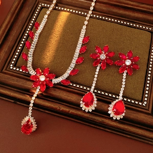 Detailed view of red gemstone flower and teardrop necklace set with silver inlay