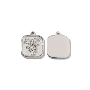 Detail of mirror polished silver square pendant with embossed rose and flat back