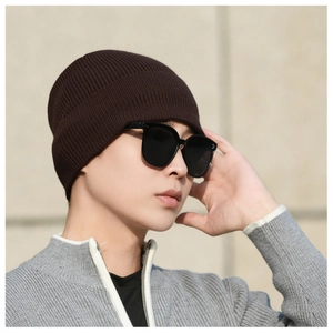 Detail of dark brown ribbed knit beanie featuring thick windproof texture for winter