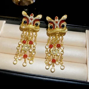 Boucles d'oreilles lion de danse dorées avec perles rouges et pompons en boîte de luxe