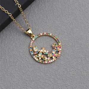 Macro detail of gold necklace with hollow round pendant and colorful stone butterfly