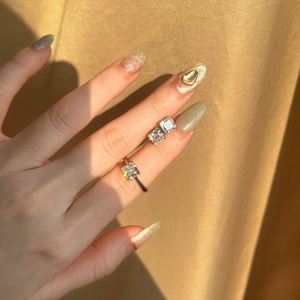 Detail of square-cut sparkling gemstone ring and earrings set on golden silk