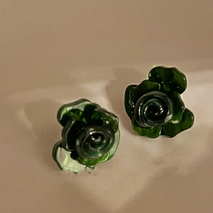 Makroaufnahme dunkelgrüner Rosenohrstecker aus Harz mit lebendigen Blütenblättern