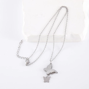 Double-layered stainless steel butterfly necklace on white decorative stone background