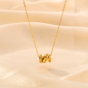 Minimalist 18K gold plated titanium necklace featuring a spiral ring pendant on a silk background