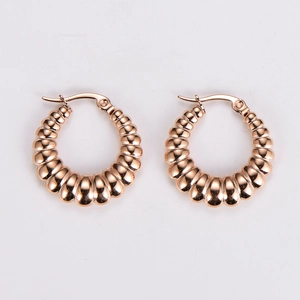 Macro detail of rose gold stainless steel hoop earrings with elegant spiral texture design