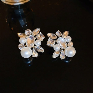 Boucles d'oreilles élégantes en perles et cristaux marquise sur surface miroir noire