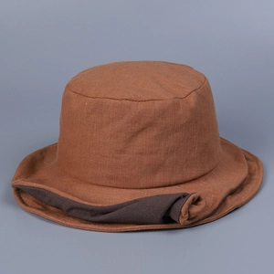 Detailed texture of brown linen bucket hat with a contrasting dark rolled brim design