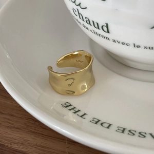 Close-up of S925 hallmark on gold irregular wave ring with open adjustable design